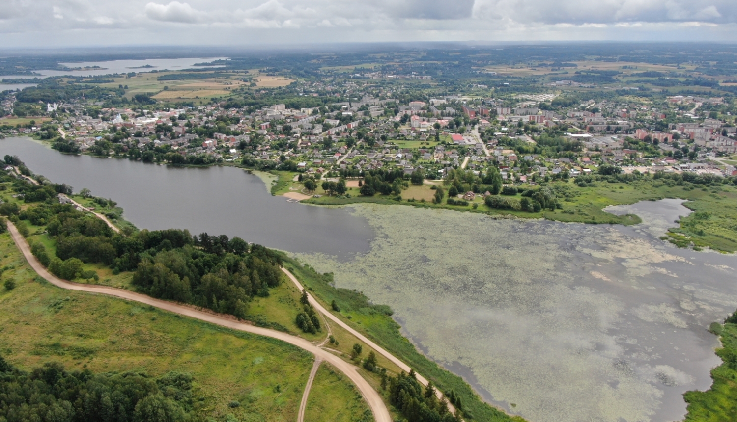 Mazā Ludzas ezera aerofoto vasarā: ezera aizauguma laukums un pilsētas panorāma fona skatā projekta "Eco-adaptive management of shallow lakes for climate resilience and biodiversity protection" ietvaros