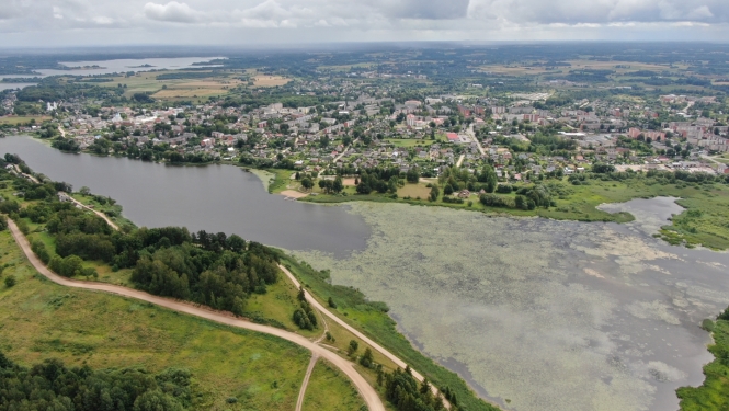 Mazā Ludzas ezera aerofoto vasarā: ezera aizauguma laukums un pilsētas panorāma fona skatā projekta "Eco-adaptive management of shallow lakes for climate resilience and biodiversity protection" ietvaros