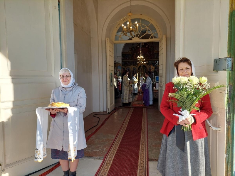 draudzes locekļi sagaida ar ziediem