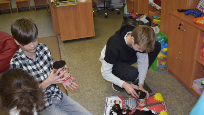 Bērni stādīja puķes, kuras pagaidām augs bibliotēkā, un bērni vēlāk varēs ieraudzīt, kas izauga no viņu iestādītajām sēklām.