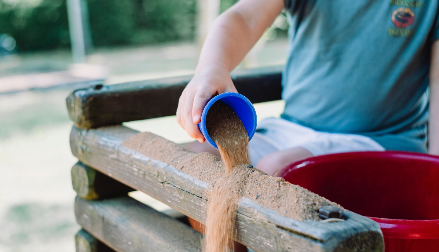 bērns spēlējas smilšukastē